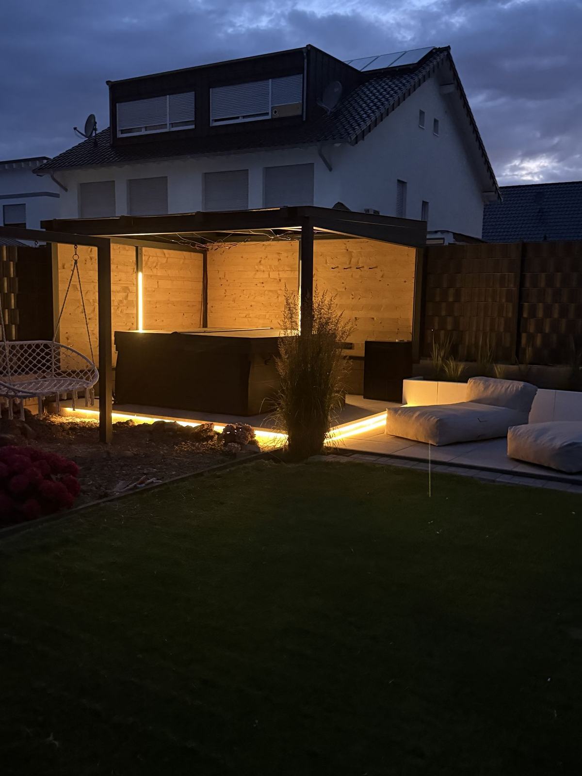 Beleuchtete Terrassenüberdachung aus Metall mit Holzverkleidung